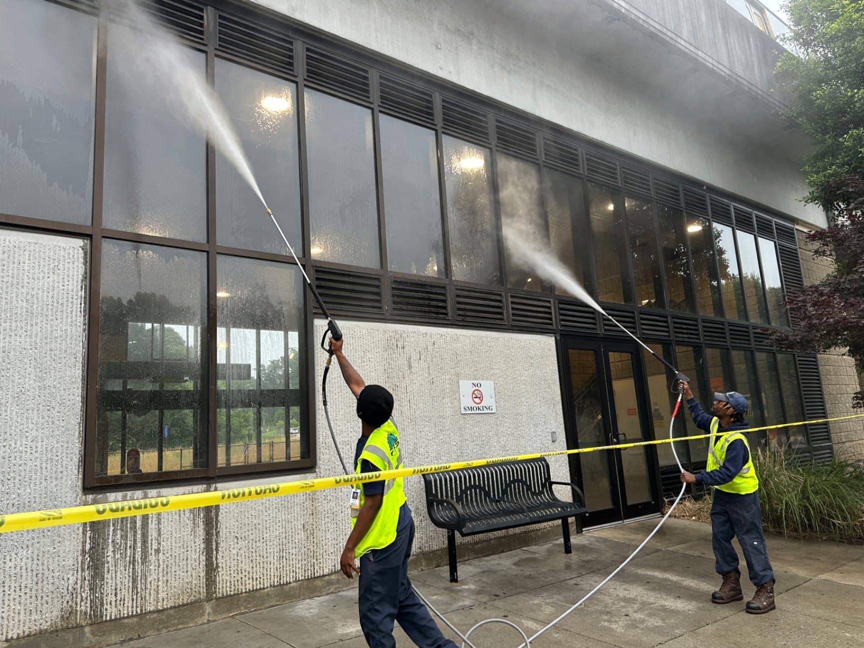 Buck A1 technicians washing the glass and concrete exterior of a commercial building