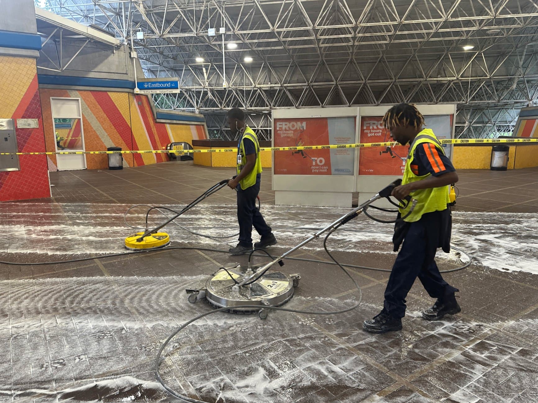 Two Buck A1 technicians running surface cleaners across a brick paver plaza
