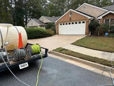 Buck A1 pressure washing trailer parked at a brick home